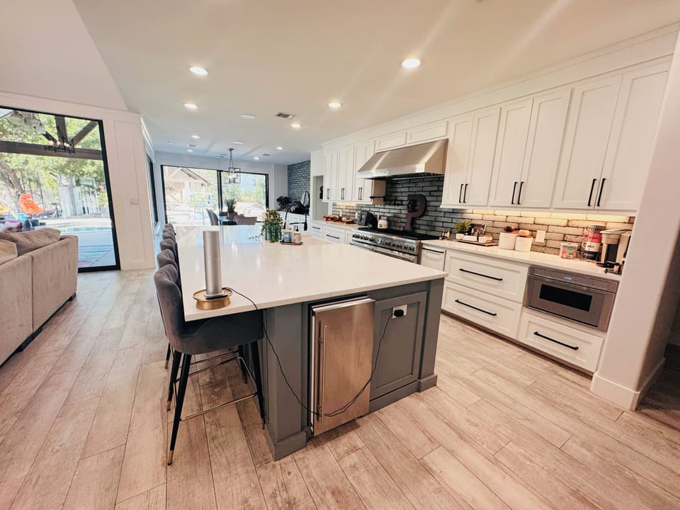 Gourmet chef's kitchen featuring a massive island with bar seating that includes