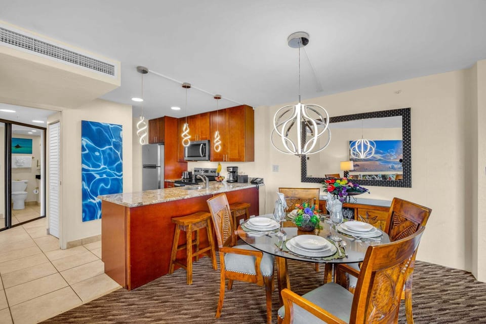 Kitchen and dining flow designed for gathering, with sleek appliances and vibrant artwork adding character.
