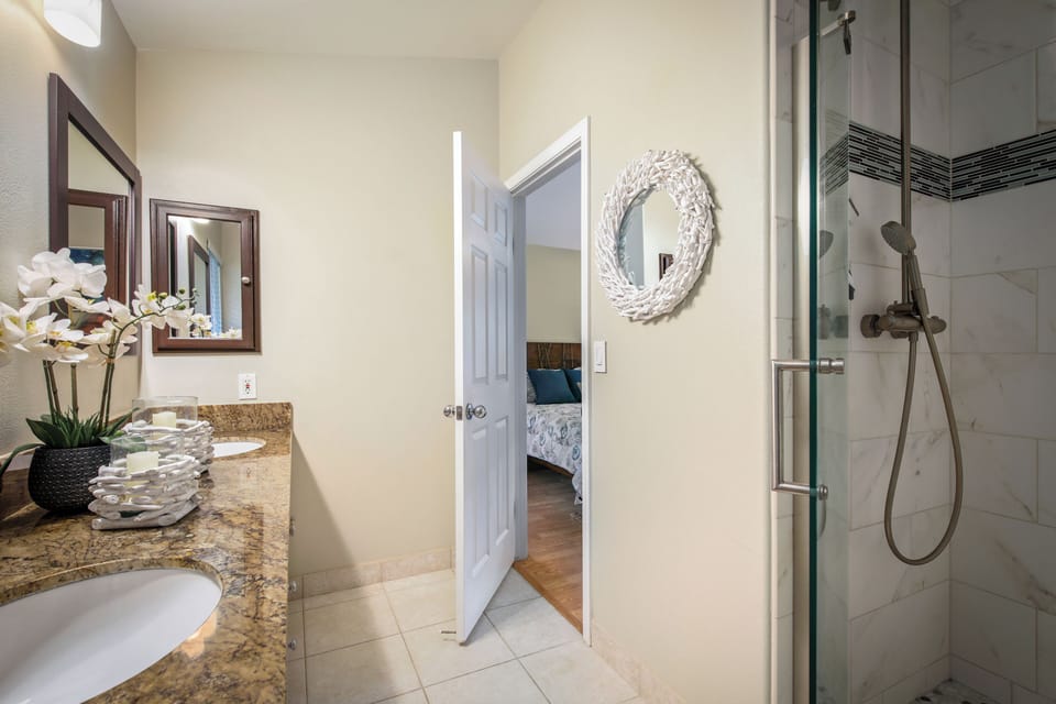 Step into your private ensuite with granite counters, a walk-in shower, and coastal-inspired decor welcoming you to unwind after a day of adventure.