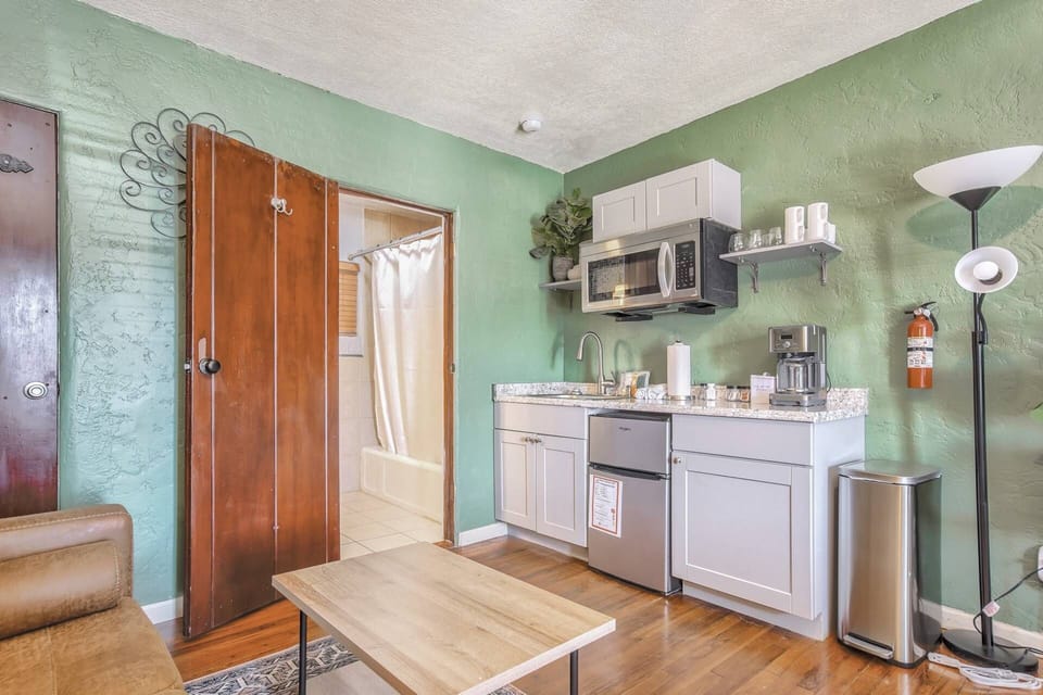 A kitchenette with coffee maker, basic dishes, a microwave and sink