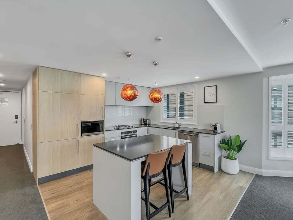 Fully equipped modern kitchen with stone benchtops, premium appliances, and everything needed for home-cooked meals.