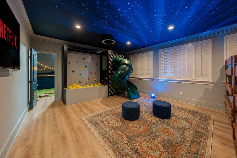 Epic kids’ playroom with indoor slide, climbing wall, and starry ceiling