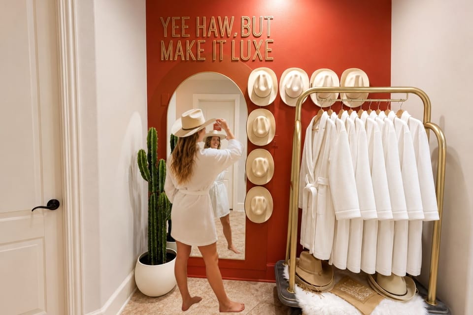 Luxe western-style dressing nook with robes, hats, and a statement mirror