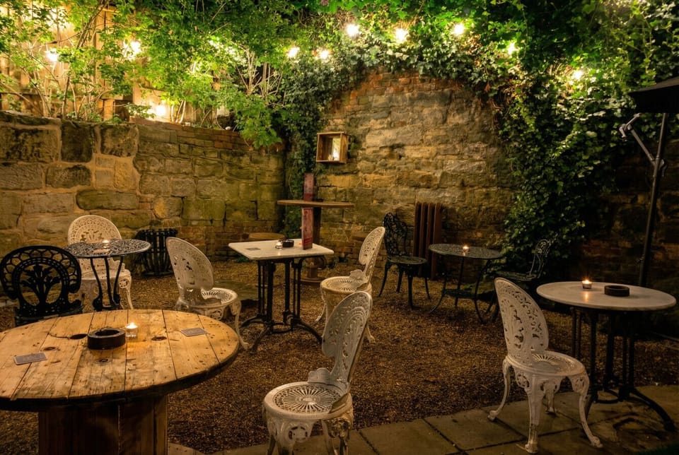 Step into the candlelit courtyard, ivy-draped walls and fairy lights setting the mood.