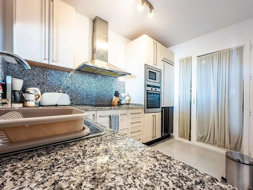 Bright modern kitchen with granite counters and built-in appliances