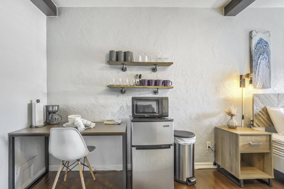 A kitchenette with a fridge, a microwave, and a coffeemaker