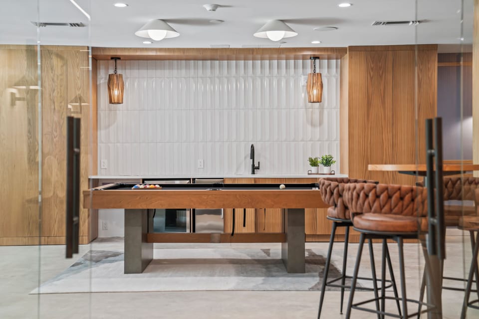 Modern lounge with pool table, bar seating, and upscale design