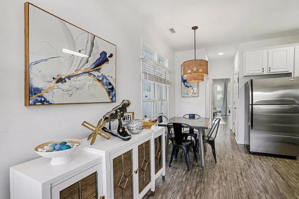 Open dining area steps from the kitchen — seats the family with coastal art all around