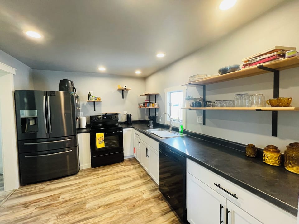Modern full kitchen with open shelving and spacious prep space