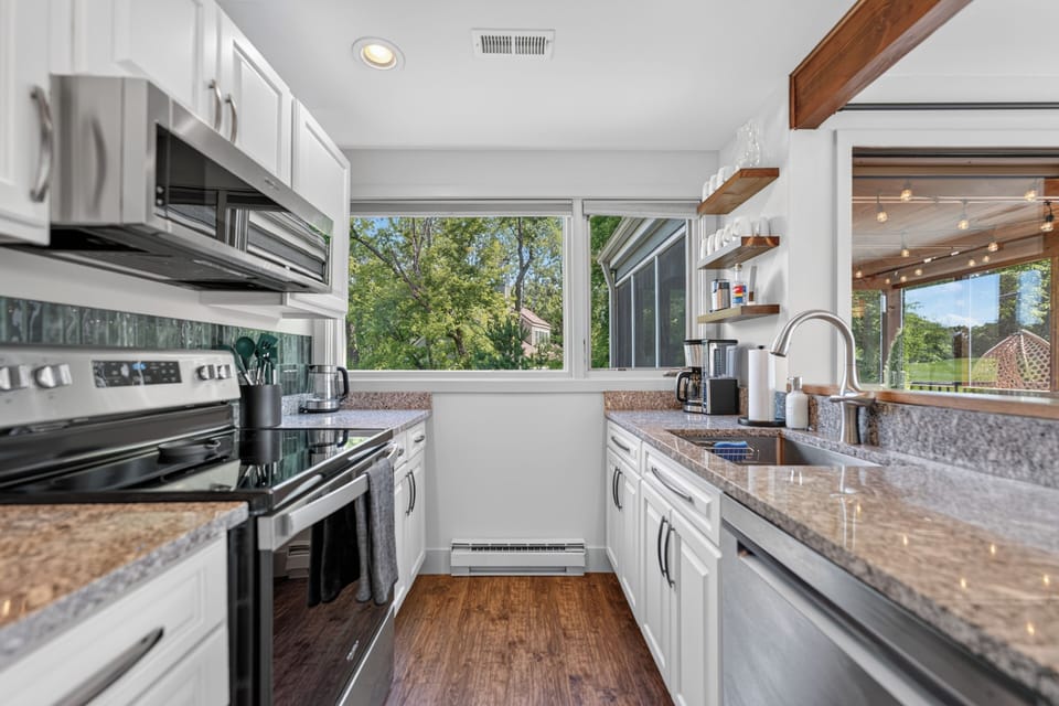 Well-stocked kitchen with ample counter space, cookware, and appliances for preparing group meals.