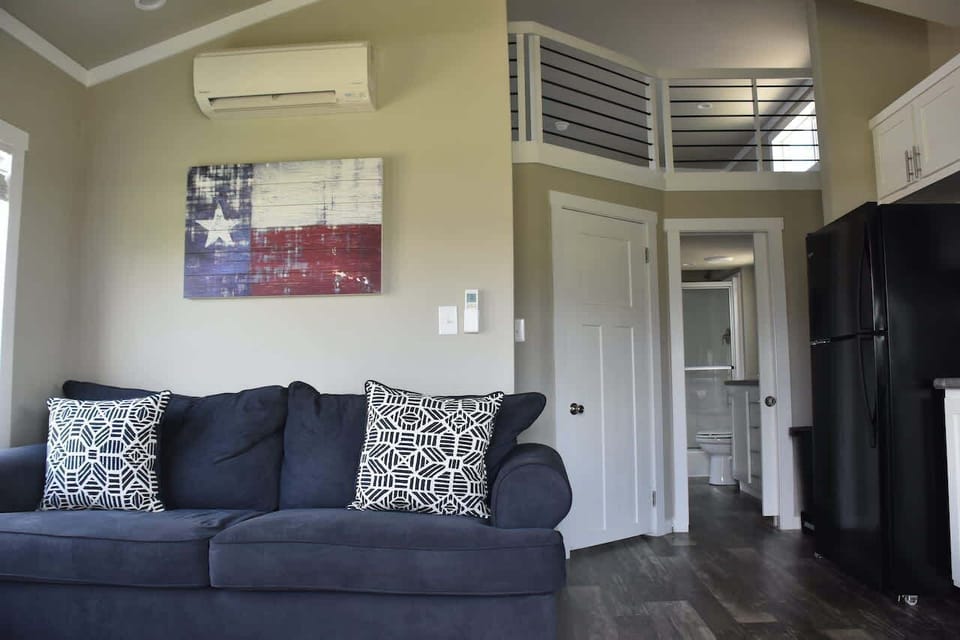 A real living room with a comfy sofa, smart TV, and AC that keeps up with Texas summers