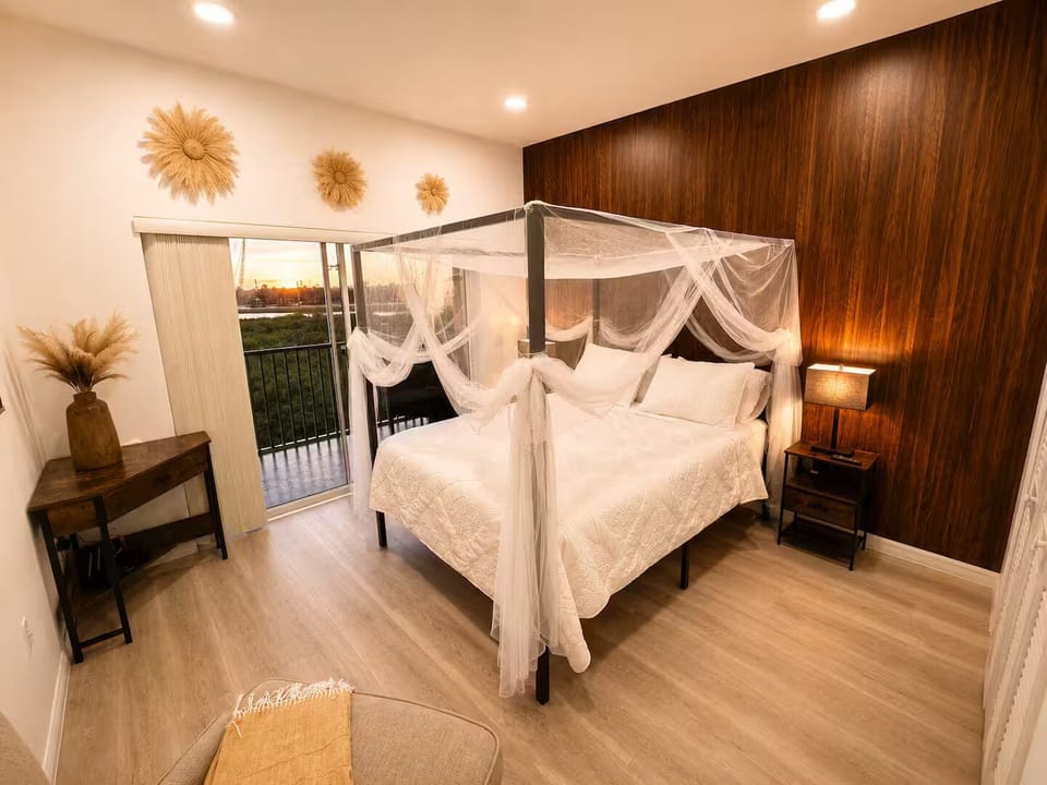Elegant canopy bedroom with a queen bed and direct access to the balcony.