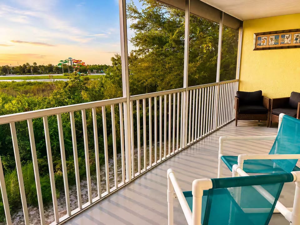 Private screened balcony with comfortable seating and peaceful sunset views.