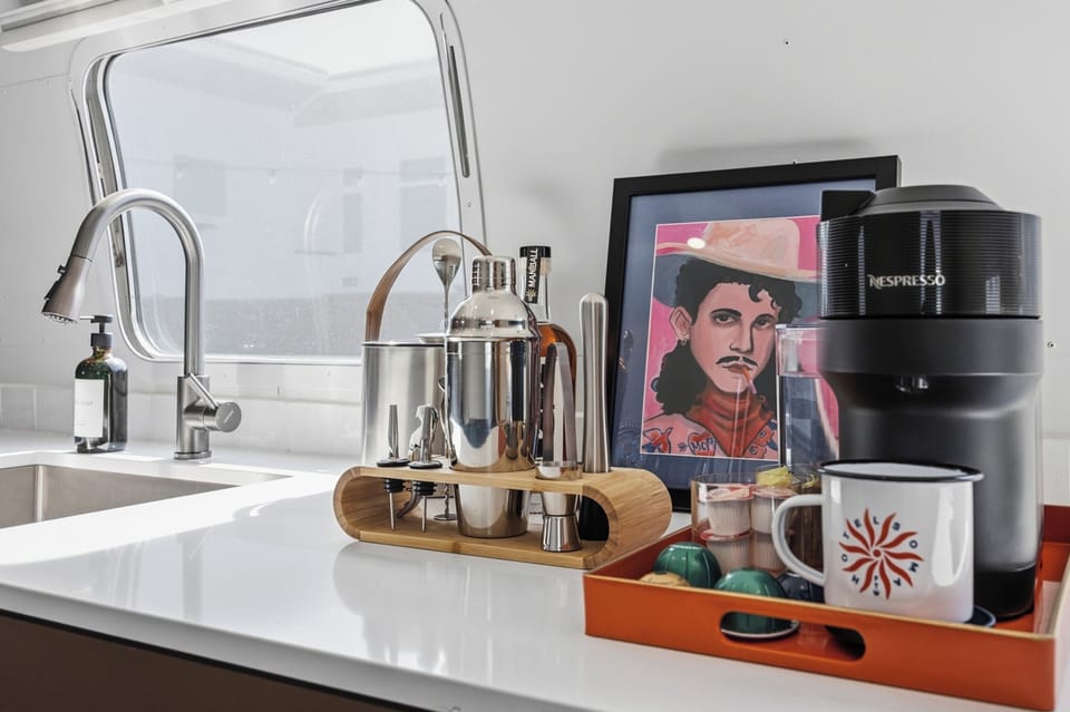 A sleek kitchenette with a fridge, prep space, and the essentials for easy mornings and simple nights in. Perfect for coffee, snacks, and reheating leftovers after a day out.