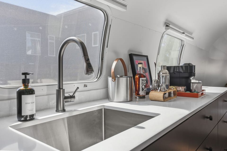 A sleek kitchenette with a fridge, prep space, and the essentials for easy mornings and simple nights in. Perfect for coffee, snacks, and reheating leftovers after a day out.