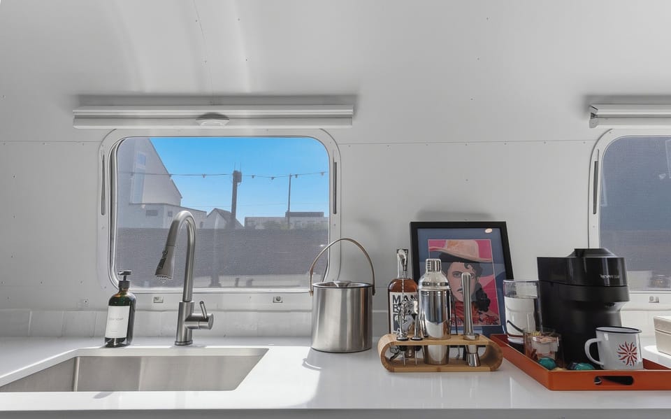 A sleek kitchenette with a fridge, prep space, and the essentials for easy mornings and simple nights in. Perfect for coffee, snacks, and reheating leftovers after a day out.