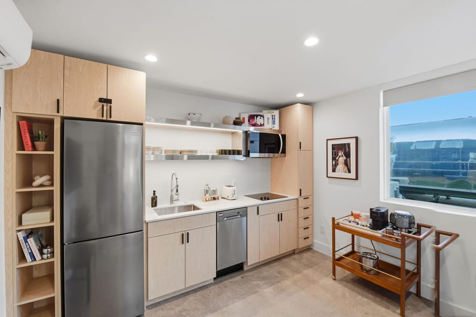 A sleek kitchenette with a cooktop and the essentials for quick breakfasts, easy nights in, and longer stays. Plenty of cabinet space for groceries.