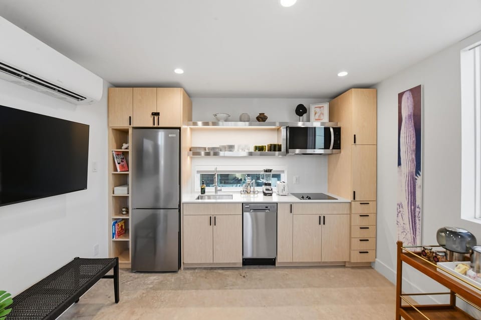 A sleek kitchenette with a cooktop and the essentials for quick breakfasts, easy nights in, and longer stays. Plenty of cabinet space for groceries.