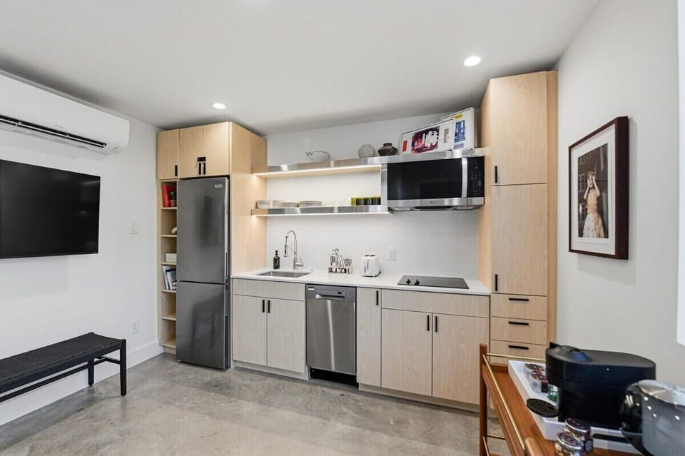 A sleek kitchenette with a cooktop and the essentials for quick breakfasts, easy nights in, and longer stays. Plenty of cabinet space for groceries.