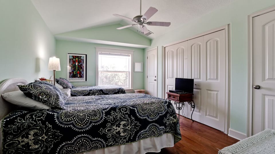 Bright twin bedroom with natural light, TV, and ample closet space