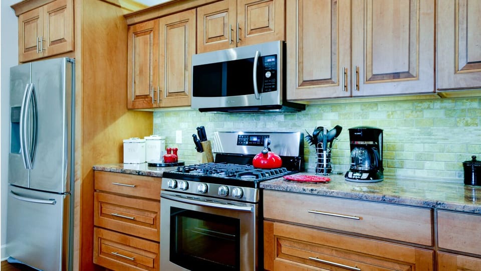 Modern kitchen with stainless appliances, gas range, and warm wood cabinets