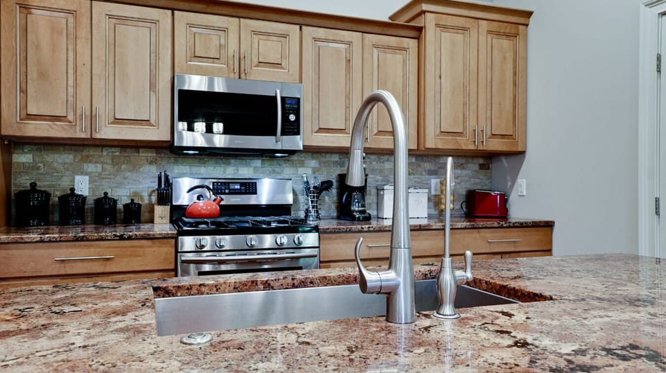 Spacious gourmet kitchen with granite island and stainless steel appliances