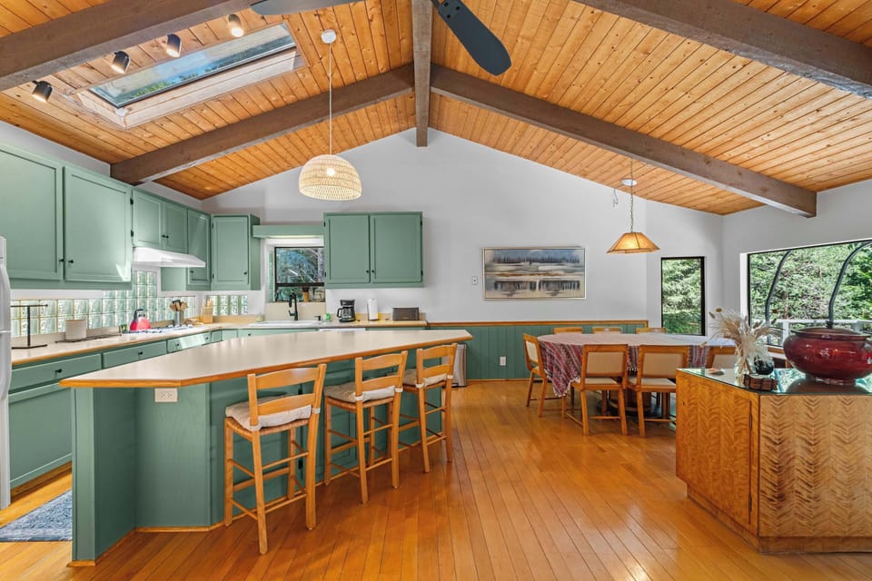 Cook in the open kitchen while dinner waits at the round table for six, with forest views through the picture windows.