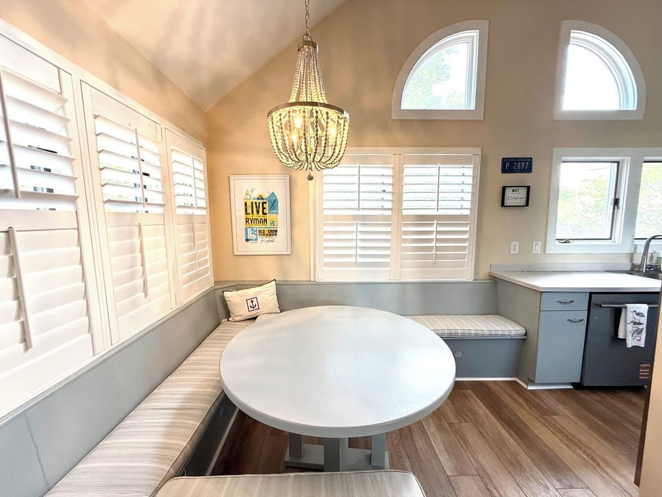 Bright, built-in breakfast nook with comfortable wrap-around bench seating underneath custom lighting.