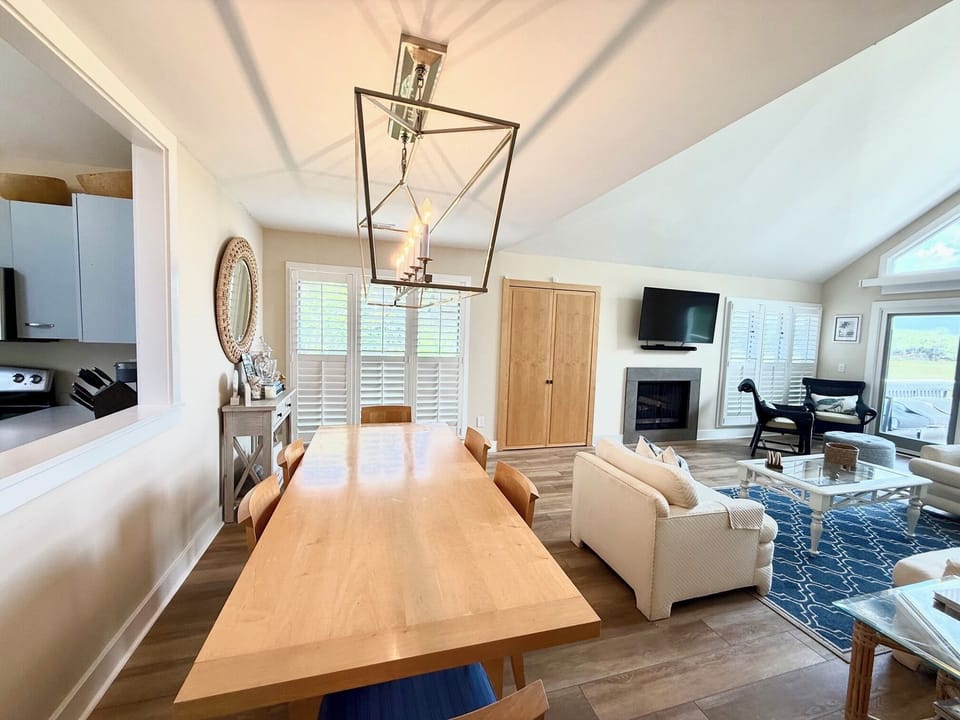 Sun-drenched upper-level living room featuring high ceilings, ample seating, and sliding doors to the deck.
