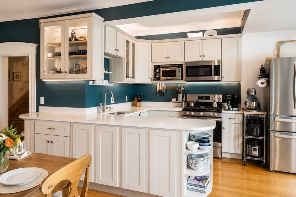 The fully equipped kitchen includes sharp knives, quality cookware, a stand mixer, toaster, and a refrigerator with a built-in water dispenser. Overlooking the dining area, it's perfect for cooking while chatting with family and friends.