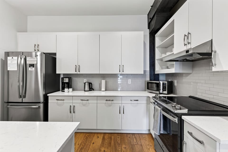 Cook and gather in the sleek kitchen, featuring a spacious island with seating for five.