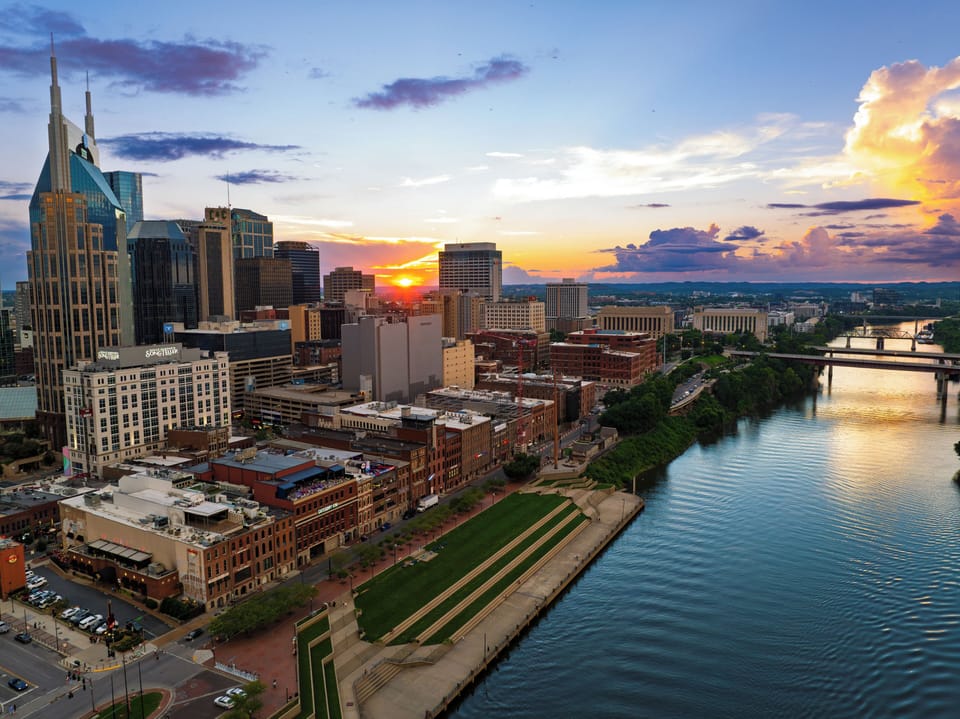 Experience Nashville’s downtown energy, riverfront parks, and iconic skyline beneath a colorful sunset.