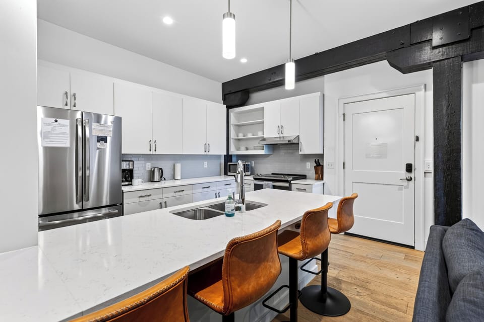 Cook and gather in the sleek kitchen, featuring a spacious island with seating for five.