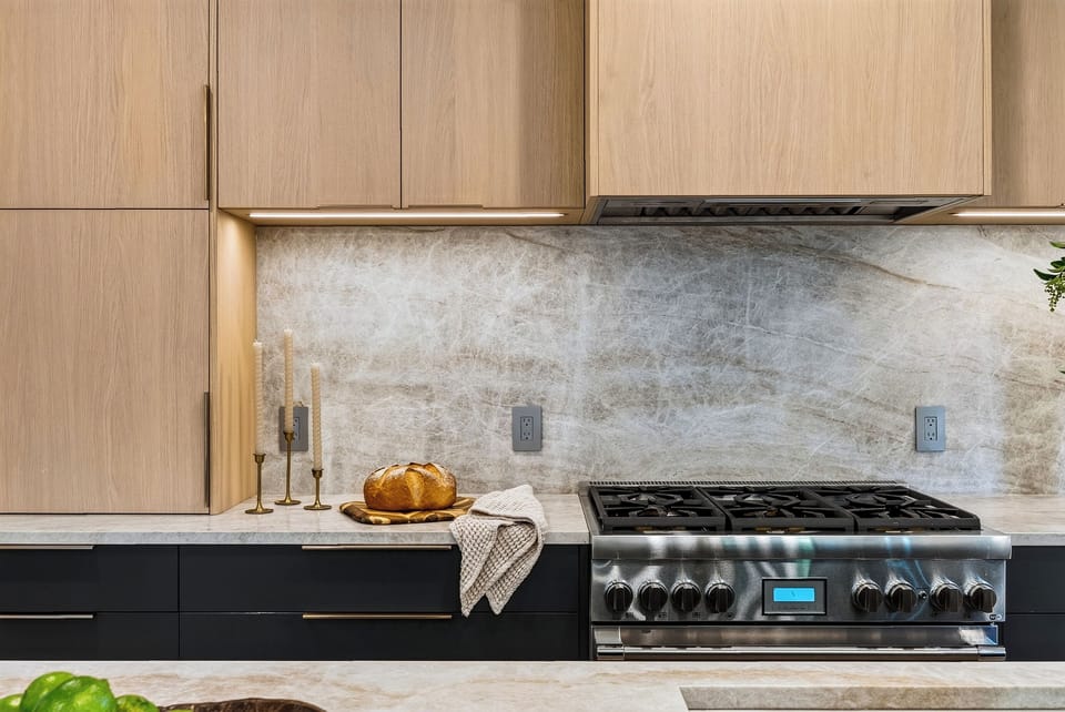 Warm modern kitchen with a fluted island, sleek black accents, and bar seating beside the dining area.