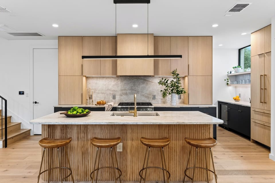 Statement kitchen with a fluted wood island, marble-style finishes, and bar seating for four.