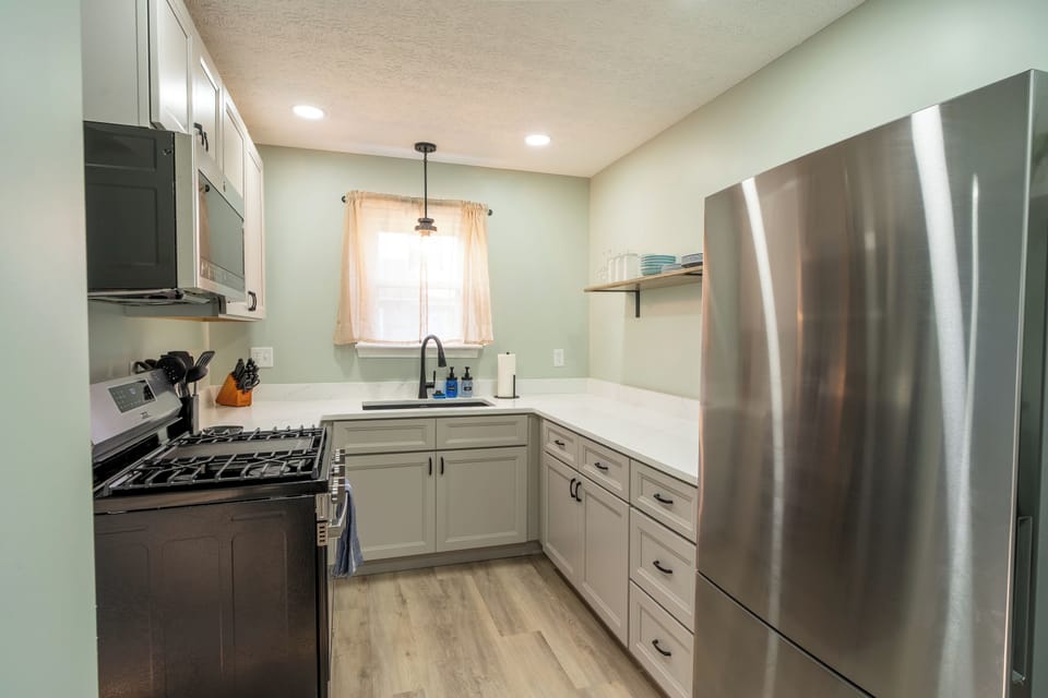 Kitchen with stainless steel refrigerator and gas range/oven