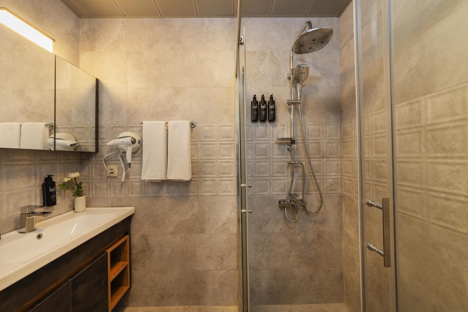 Losta Grand Room | Bathroom | Shower, hair dryer, slippers, towels