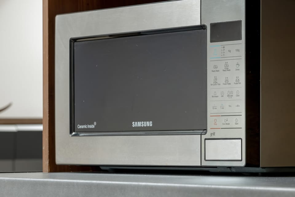 A close-up shot focuses on a built-in stainless steel microwave mounted inside modern cabinetry. Sleek metallic finishes give the appliance a clean look.