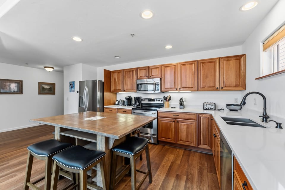 Your fully equipped kitchen invites you to cook up a feast with warm wood cabinetry, modern stainless appliances, and a spacious island for gathering over meals.