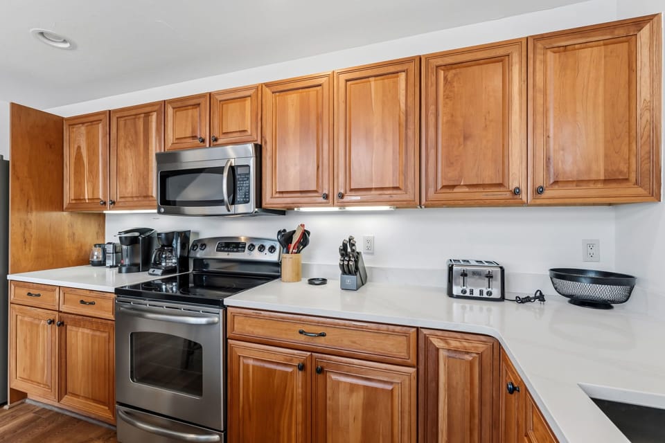 Your fully-equipped kitchen features warm wood cabinetry, modern stainless appliances, and everything you need to prepare meals at your leisure during your stay.