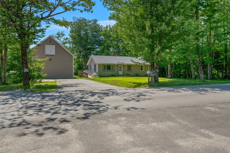 Pull directly into the wide, paved driveway providing plenty of space for multiple vehicles. This entry point connects to the gravel loop for pull-through trailer parking, offering convenient maneuverability for boats, ATVs, and large rigs.