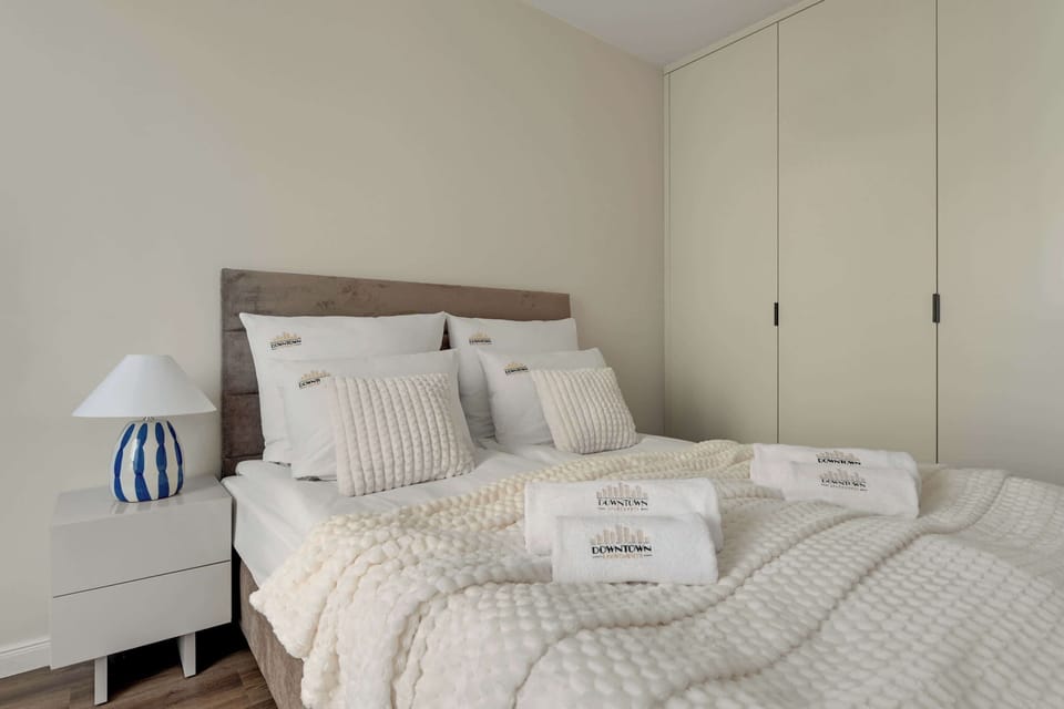 Strefa sypialniana została częściowo oddzielona od salonu. Znajduje się w niej wygodne łóżko małżeńskie z hotelową pościelą i kompletem poduszek. Pojemna szafa w przedpokoju zapewnia miejsce do przechowywania rzeczy.