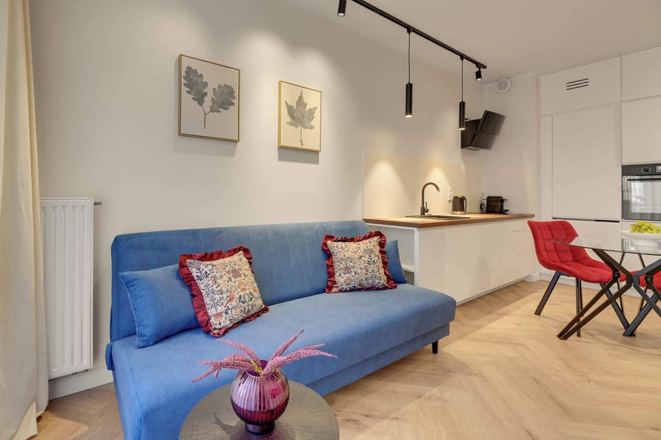 Przestrzeń dzienna została zaprojektowana z myślą o komforcie i odpoczynku. Znajduje się tu wygodna rozkładana sofa. Naprzeciwko ustawiono telewizor z funkcją Smart TV, idealny do wieczornego relaksu przy ulubionym filmie lub serialu.