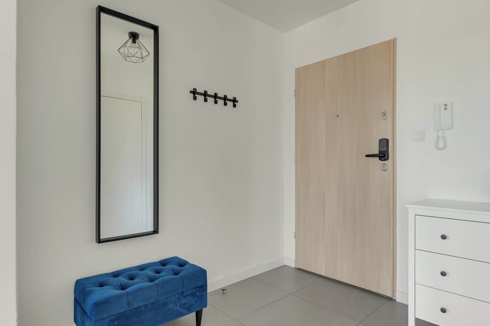 Apartament oferuje jasny salon z rozkładaną sofą, telewizorem, klimatyzacją oraz częścią jadalnianą. Duże przeszklenia prowadzą na przestronny balkon z meblami wypoczynkowymi i widokiem na okolicę.