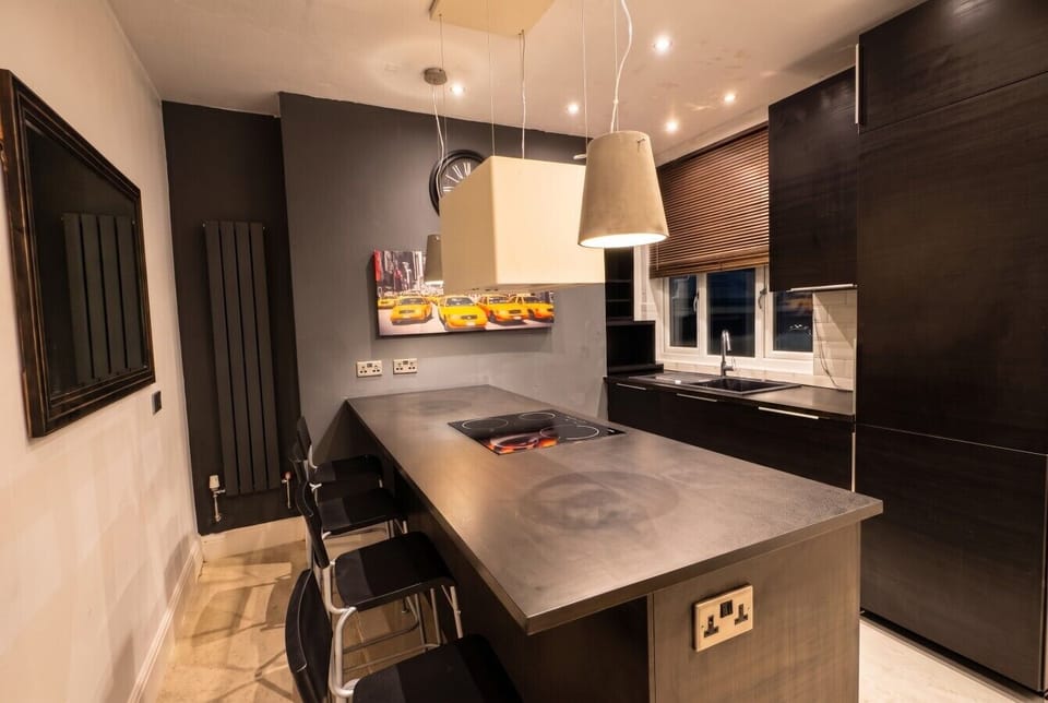 Modern kitchen with breakfast bar seating and Netflix TV
