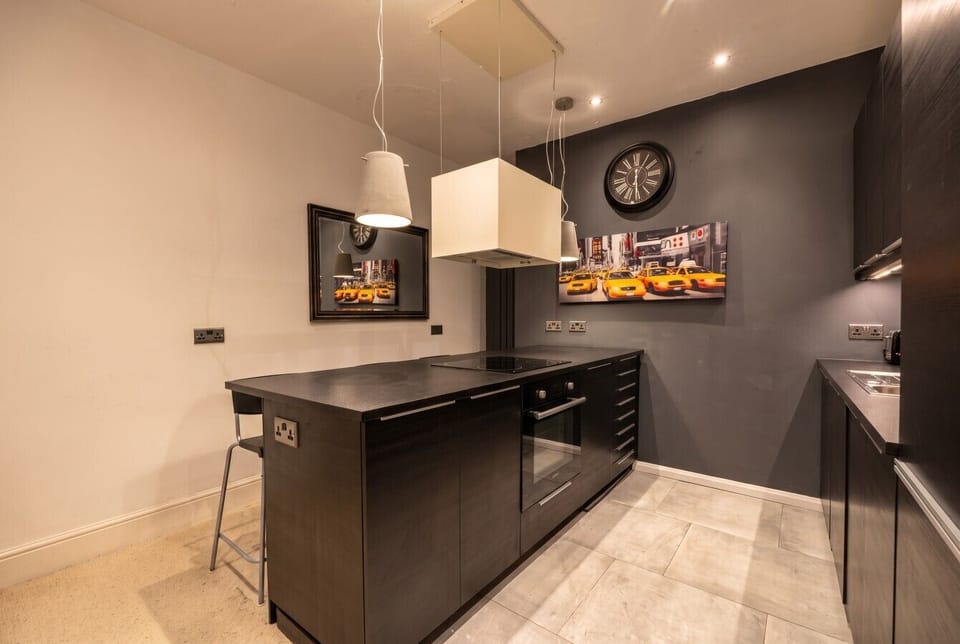 Sleek dark kitchen with hob, oven and city-cool styling