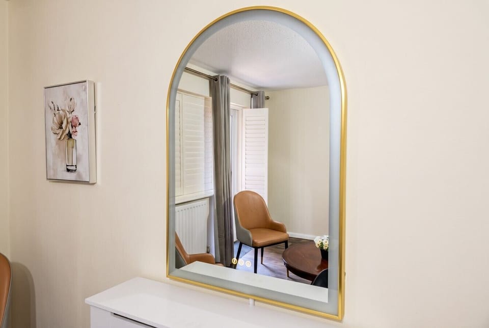 Elegant gold mirror reflecting the calm sitting area beyond
