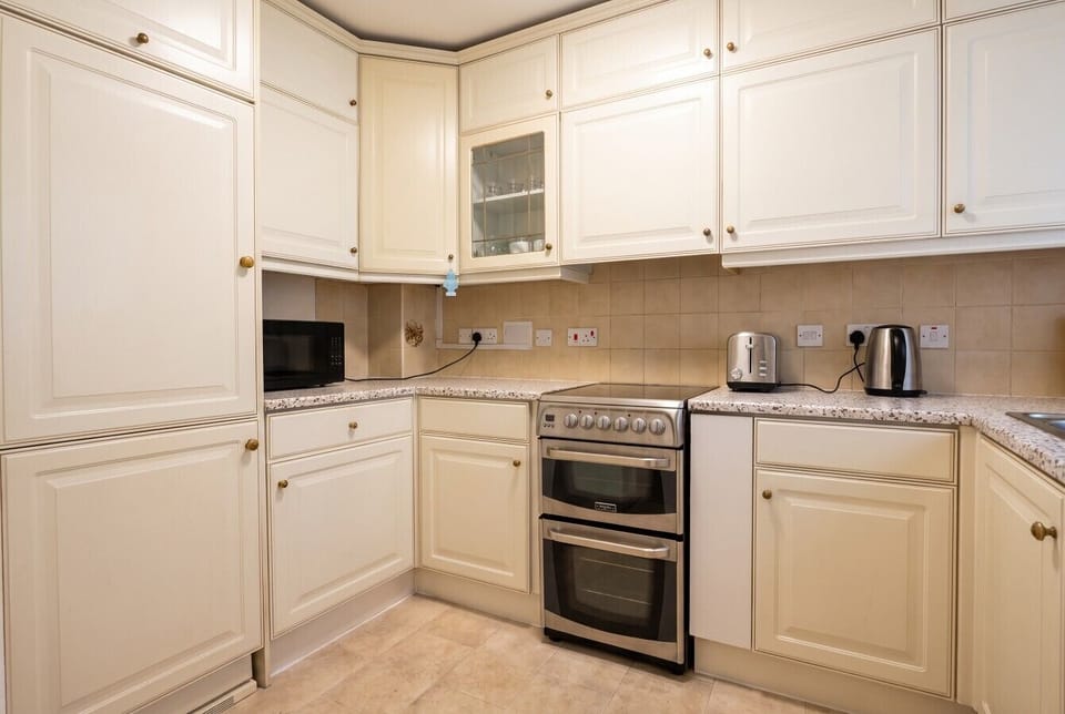 Cream kitchen with double oven, toaster and kettle for easy home cooking