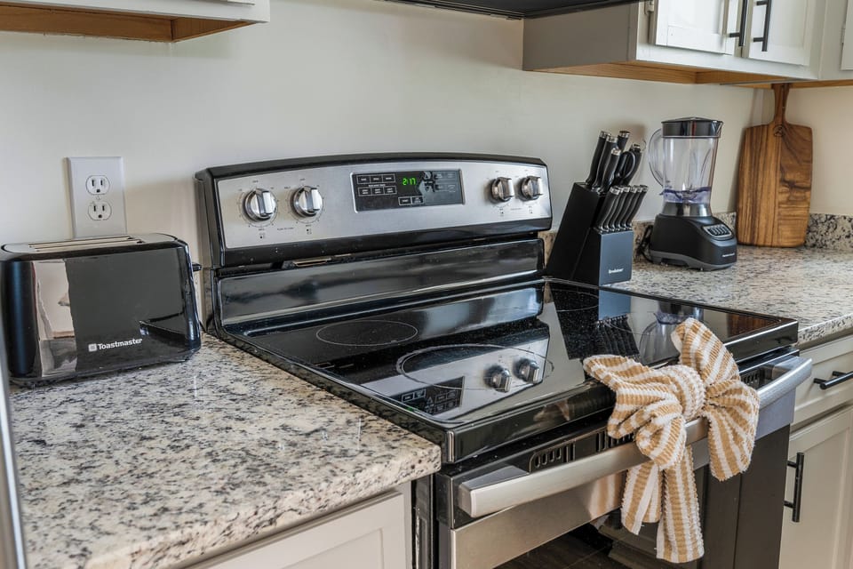 Toaster, Stove, Kitchen knives, Blender, and cutting board for guest use.