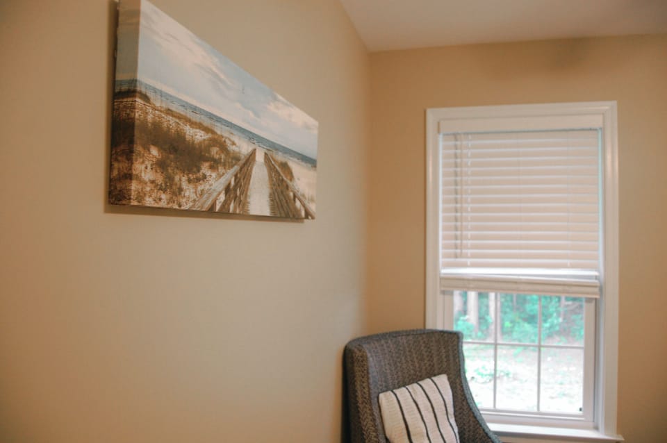 📖 A cozy reading nook with a comfy accent chair, beautiful natural light, and coastal-inspired artwork. ☀️ The perfect spot to enjoy a morning coffee, dive into a good book, or simply unwind during your stay.